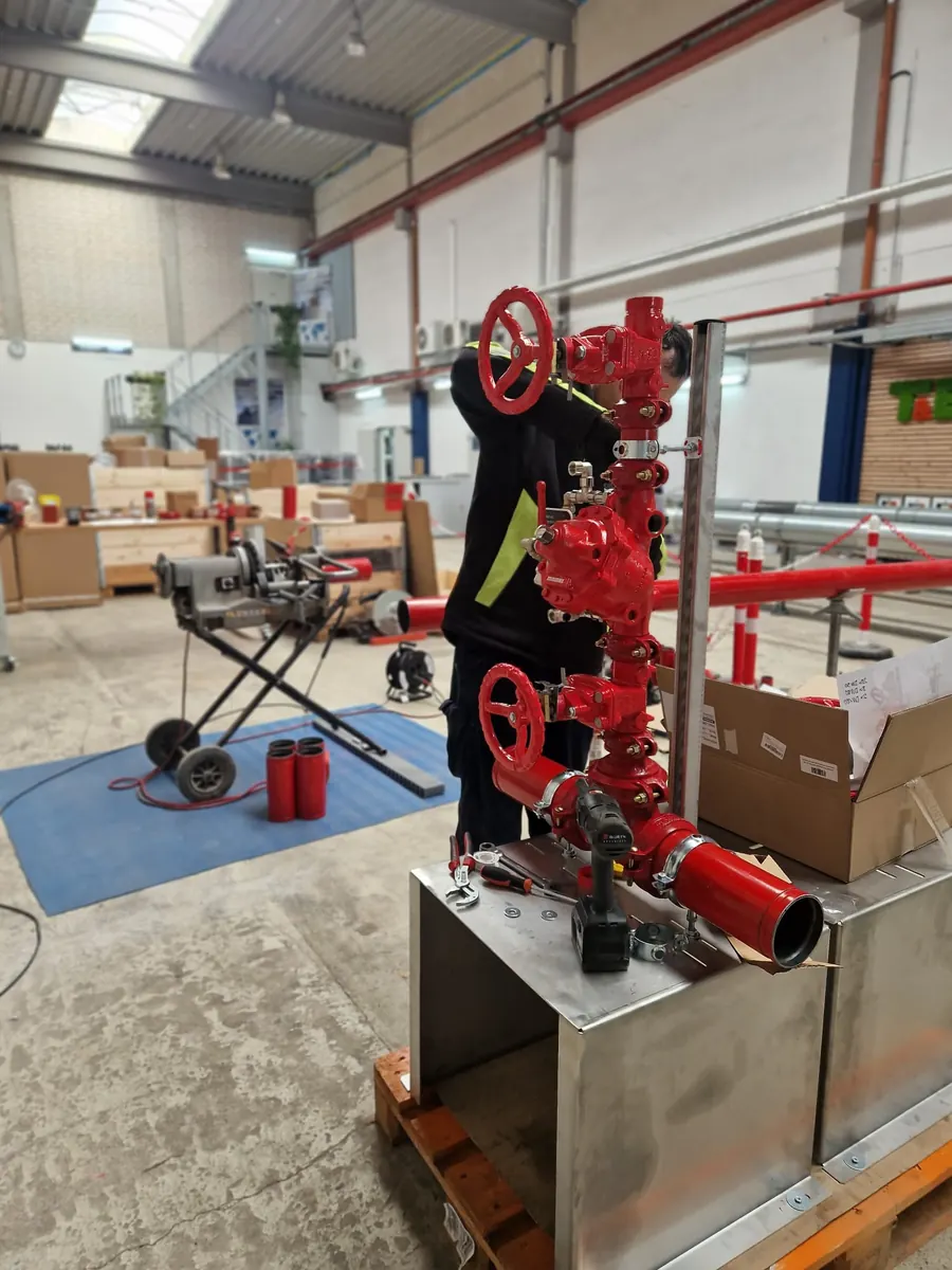 Worker prefabricating an industrial valve assembly